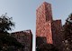 A rendering from a street-level view of a high-rise building with brown textured walls and differently shaped cutouts.