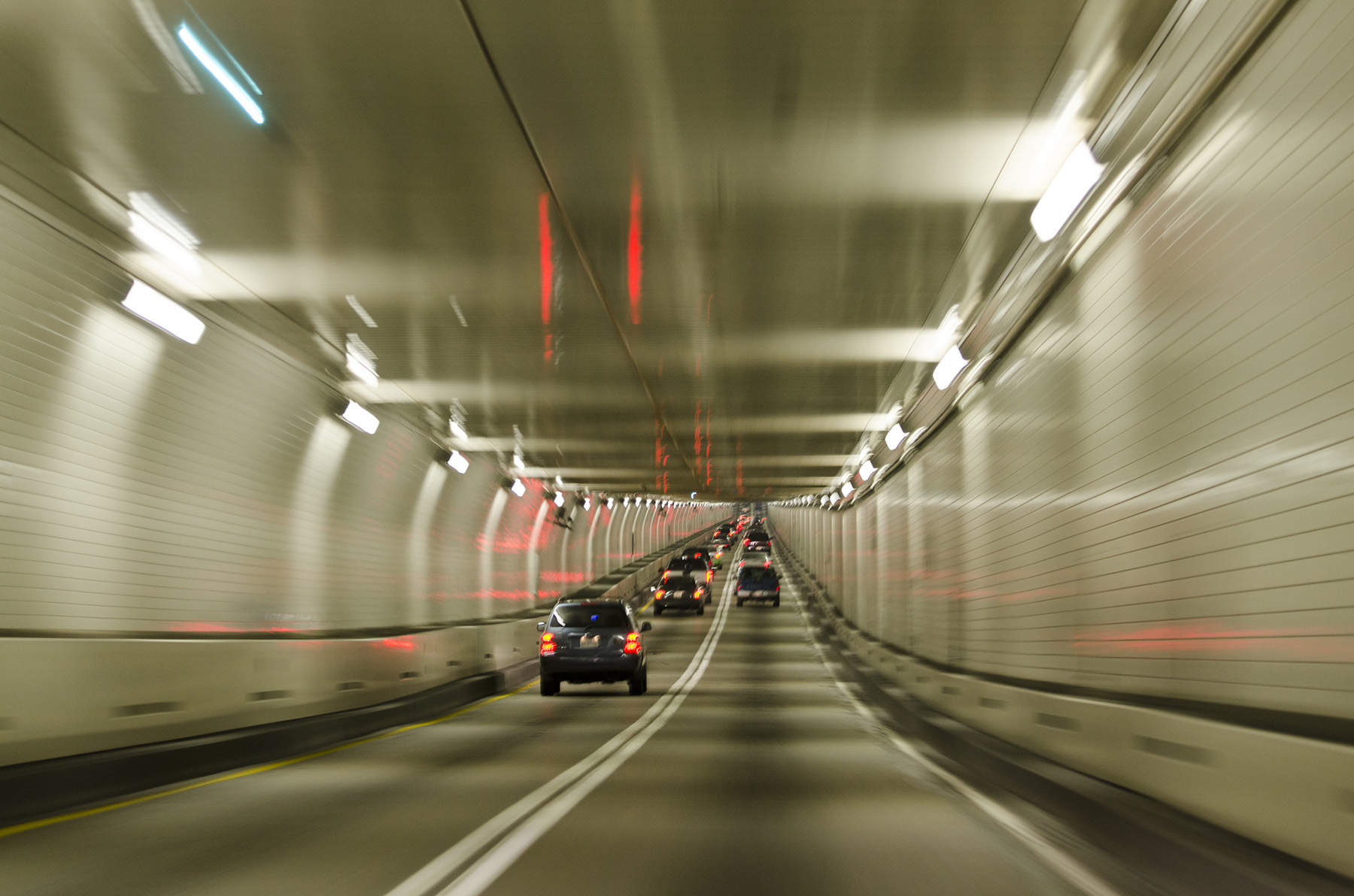 Cars travel through a tunnel. 