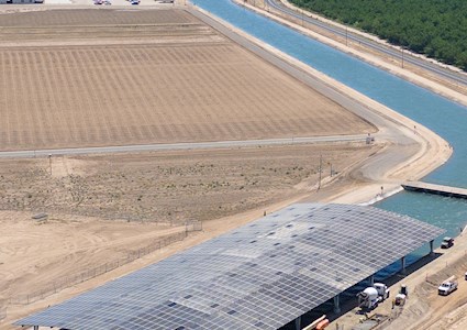 aerial image of solar panels over a wide canal
